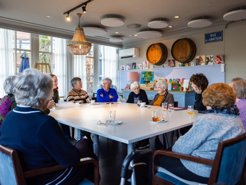 Ouderen aan een lange tafel in de dagbeleving van Valckenborgh