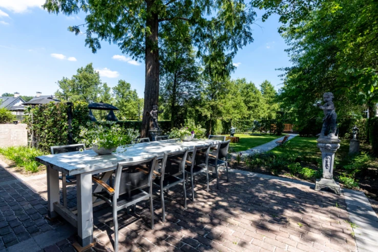 Terras met lange tafel in de belevingstuin van Valckenborgh